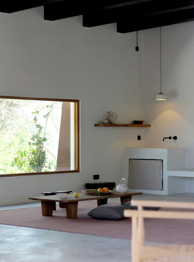Modern living room with wooden coffee table, fireplace, and large window.