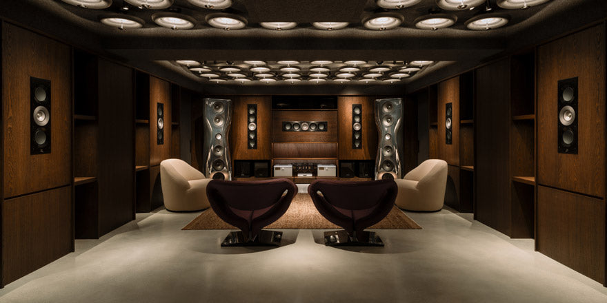 Luxury home theater with wooden walls, ceiling lights, and modern furniture.