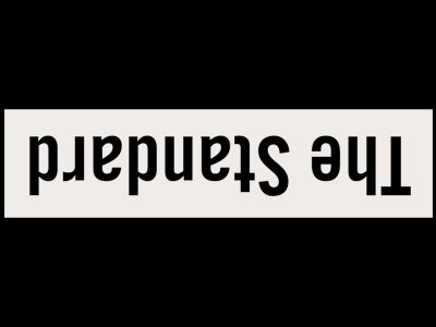 White rectangular sign with 'The Standard' text on a black background