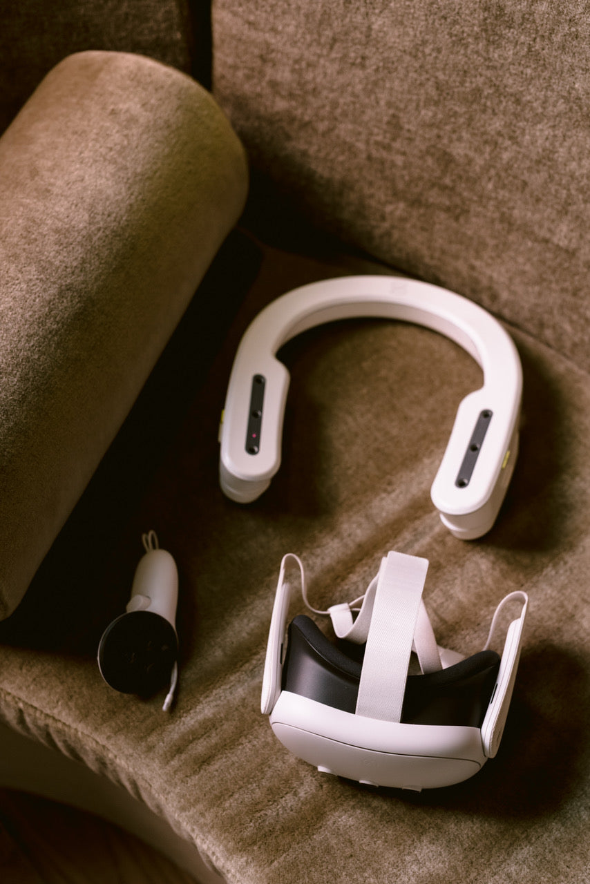 White neck massager and headband on a brown surface